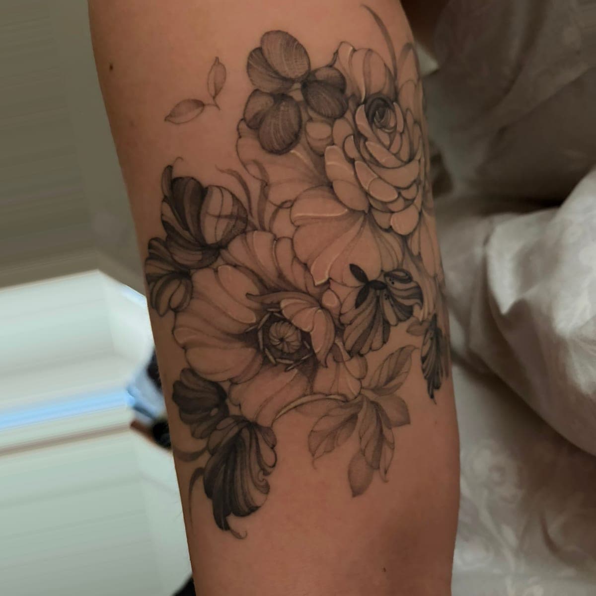 Healed black and grey flowers on the back of an arm