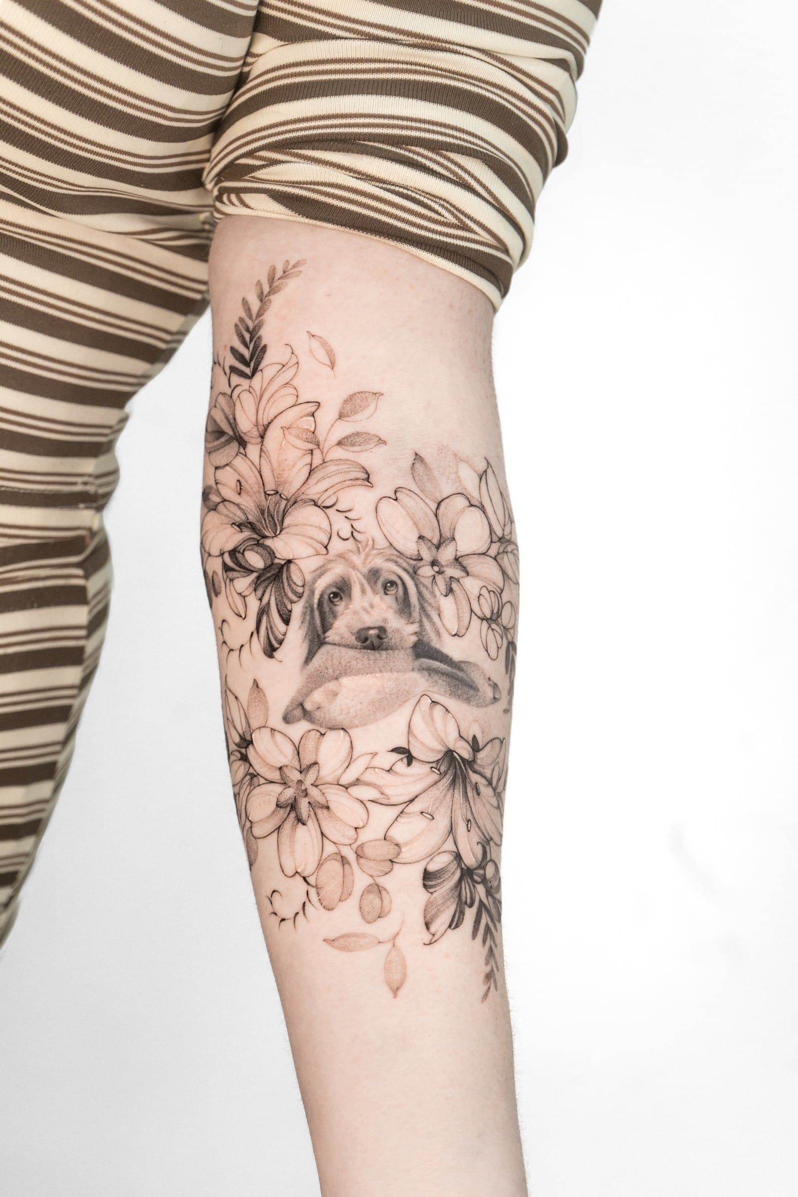 Dog amongst blossom, tattoo by Nicolly