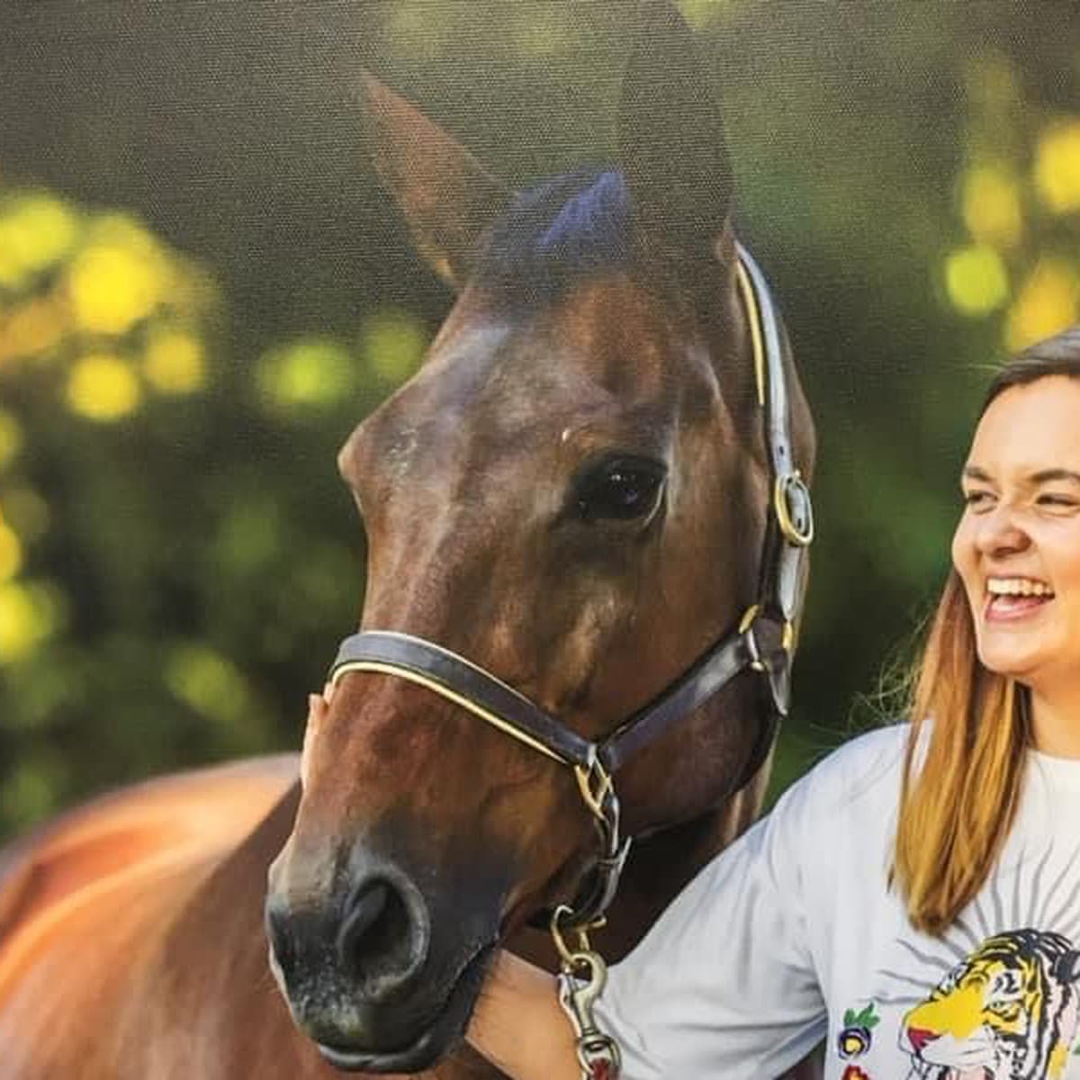 Boo, a bay mare in a leather headcollar, with Aisha laughing beside her
